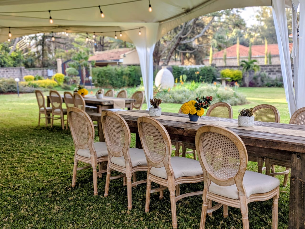 Garden tent with long wooden tables set for a Nairobi event