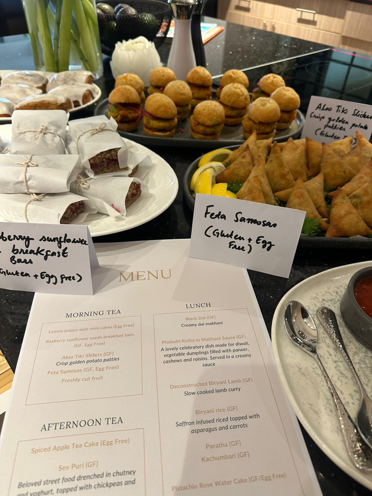 Canapés and printed menu — feta samosas, sliders, breakfast bars